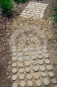 Garden path made of natural wooden planks, stones, gravel. Healthy sensory path with different surfaces