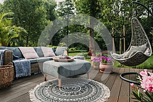 Garden patio with Scandinavian wicker sofa and coffee table