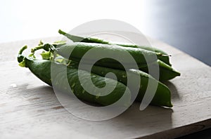 Garden pea (Pisum sativum), closed pods on a chopping board