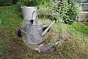 Garden planting. Empty pots, gloves and a trowel lie on the lawn