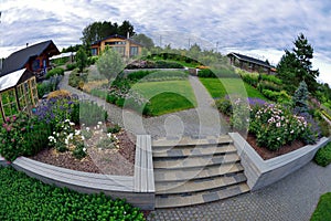 Garden plot with a house, flowerbeds and paving