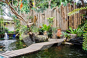 garden with pond of koi fish and decorated bamboo wall