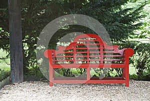 Garden with red oriental style bench under a tree