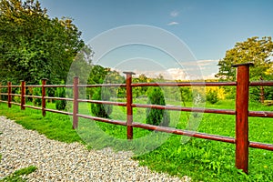 Garden red wooden fence and green grass photo