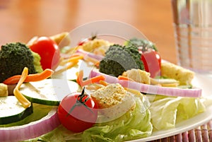 Garden salad on table setting with glass of water