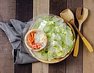 Garden salad on wooden plate with fix ins on the side