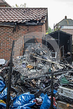 Garden shed fire. Charred remains and house garage damage