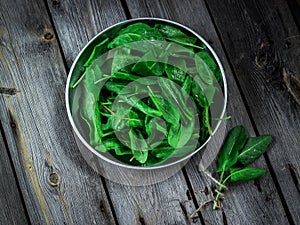 Garden sorrel in a bowl on wooden table. Style rustic. .