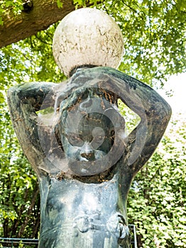 garden statue.  child figure with lamp globe on his head.  dirty with cobwebs.