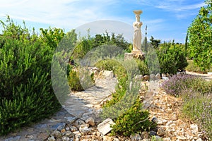 Garden with stones and Greek statue.