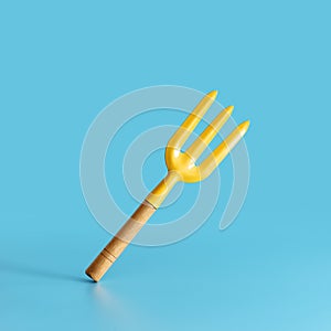 Garden tool. Yellow fork on blue background