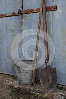 A garden tools stands against an old wall
