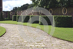 Garden wall, statues, topiary, and pathway