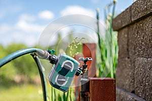 Garden water timer on a spigot with a splitter and hoses.