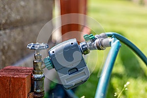 Garden water timer on a spigot with a splitter and hoses.