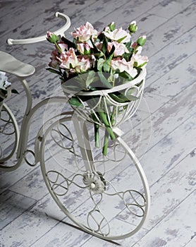 Garden white bicycle with a a basket of flowers roses