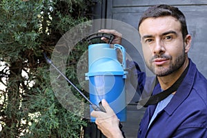 Gardener in blue uniform holding fumigation equipment
