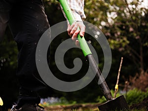 Gardener digging garden with spade medium