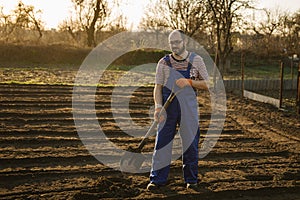 The gardener digs the garden with a shovel