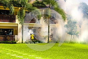 A gardener doing a poisoning activities by spraying insecticide or pesticides to control the insects in hotel. Thailand