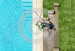 Gardener Finishing Lawn Around Swimming Pool