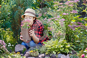 Gardener girl smelling flowers in garden