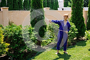 Gardener girl is watering the garden