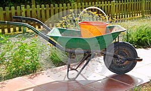 Gardener green wheel barrow with orange pail