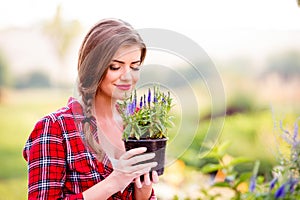 Gardener holding a seedling in flower pot, smelling it