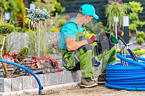 Gardener Installing Garden Irrigation Sprinklers