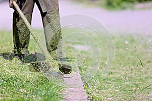 Gardener landscaper worker cutting green grass