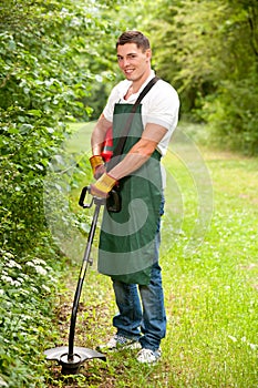 Gardener with lawn trimmer