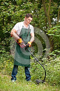 Gardener with lawn trimmer