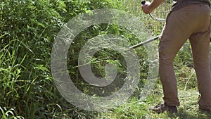 Gardener man mowing the grass, petrol lawn mower for cleaning the area