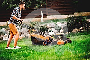 Gardener mowing the lawn using a professional lawnmower