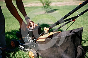 Gardener mows the lawn in the garden with a lawn mower in summer