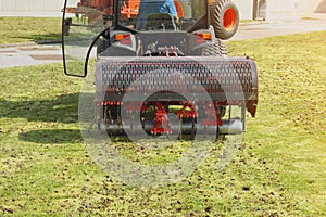 Gardener Operating Soil Aeration Machine on Grass Lawn