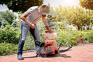 Gardener in protective mask and glasses spraying toxic pesticides trees