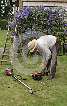 Gardener with tools to cut a hedge