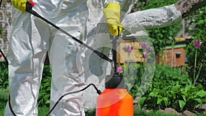 Gardener using pump sprayer for fertilizing trees