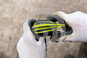 The gardener winds the fishing line around the head of the trimmer. Replacing consumables for lawn mowers