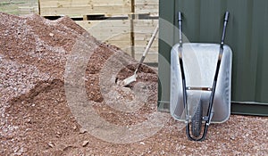 Gardening and building tools  -  wheelbarrow, spade and heap of stone grit