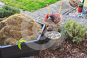 Gardening - composter, bucket with stones and wheelbarrow with soil