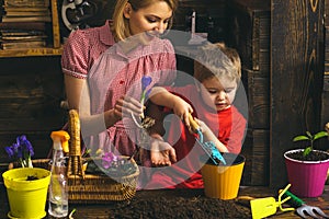 Gardening concept. Little child help mother planting flower in pot with gardening tool. Organic gardening. Gardening is