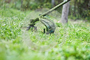 Gardening. Cutting the lawn with cordless grass trimmer, edger