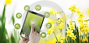 Gardening equipment e-commerce concept, online shopping on digital tablet, hand pointing and touch screen with tools icons, on