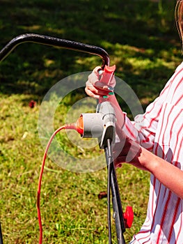 Woman being mowing lawn with lawnmower