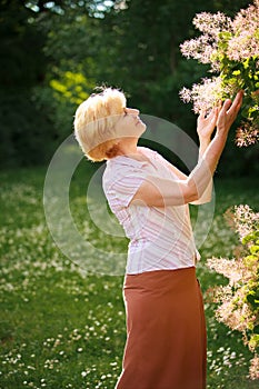 Gardening. Gracious Senior Woman and Flowers