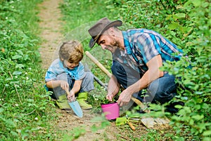 Gardening hobby. Dad teaching little son care plants. Spring gardening routine. Planting flowers. Little helper in