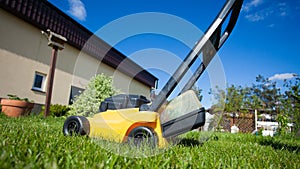 Gardening. Mowing lawn with yellow lawnmower